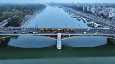 Budapeşte Margaret Köprüsü ya da Margit 'in havadan görünüşü Tuna Nehri' nin üzerine gizlenmiş. Şehirde toplu taşıma. Sarı tramvay köprüden geçiyor.