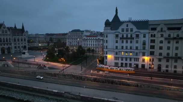 青い時間の間に都市周辺を通過する典型的なブダペストトラムの空中ビュー 空中追跡は広い角度で撮影した後 ハンガリー — ストック動画