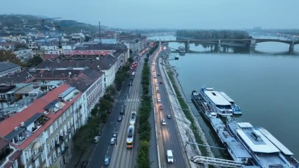 布达佩斯玛格丽特桥或玛吉特的空中景观隐藏在多瑙河的堤岸上 城市的公共交通 穿过大桥的黄色电车 — 图库视频影像