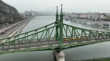 Budapeşte Szabadsag 'ın hava görüntüsü Özgürlük Köprüsü veya Özgürlük Köprüsü' nü gizledi, Buda ve Pest 'i Tuna Nehri' nin karşısına bağladı. Tarihi şehirde ikonik köprü boyunca bir tramvay dolaşır.