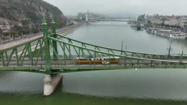 Budapeşte Szabadsag 'ın hava görüntüsü Özgürlük Köprüsü veya Özgürlük Köprüsü' nü gizledi, Buda ve Pest 'i Tuna Nehri' nin karşısına bağladı. Tarihi şehirde ikonik köprü boyunca bir tramvay dolaşır.