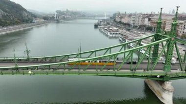 Budapeşte Szabadsag 'ın hava görüntüsü Özgürlük Köprüsü veya Özgürlük Köprüsü' nü gizledi, Buda ve Pest 'i Tuna Nehri' nin karşısına bağladı. Tarihi şehirde ikonik köprü boyunca bir tramvay dolaşır.