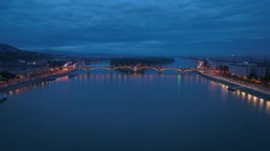 Budapeşte Margaret Köprüsü ya da Margit 'in havadan görünüşü Tuna Nehri' nin üzerinde gece boyunca gizlendi. Şehirde toplu taşıma. Tipik sarı tramvay köprüden geçiyor.