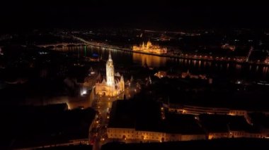 Macaristan 'ın Budapeşte kenti, ünlü Balıkçı Kalesi ve Matthias Kilisesi' nin üzerinden Macaristan Parlamentosu 'nun da desteğiyle Tuna Nehri' ne doğru uçuyor. Gece hava görüntüsü