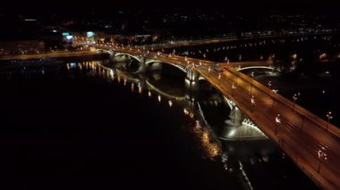 Budapeşte Margaret Köprüsü ya da Margit 'in hava manzarası Tuna Nehri' nin üzerinde, geceleri setin üzerinde saklanıyordu. Şehirde toplu taşıma. Sarı tramvay köprüden geçiyor.