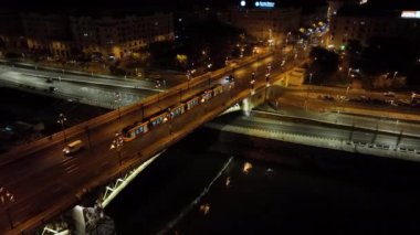 Budapeşte Margaret Köprüsü ya da Margit 'in hava manzarası Tuna Nehri' nin üzerinde, geceleri setin üzerinde saklanıyordu. Şehirde toplu taşıma. Sarı tramvay köprüden geçiyor.