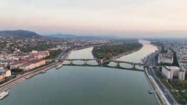 Macaristan 'ın Budapeşte kentinin güneş doğarken havadan görüntüsü alınıyor. Margaret Köprüsü ya da Margit, Tuna Nehri 'nin üstüne saklanmıştı. Şehirde toplu taşıma