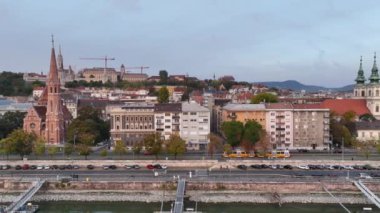 Tipik Budapeşte Tramvayı, altın saatinde güzel bir mahalleden geçiyor. Güneş doğuyor, hava takibi geniş açıdan çekiliyor.