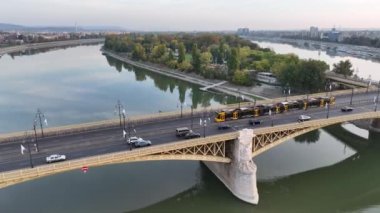 Budapeşte Margaret Köprüsü ya da Margit 'in havadan görünüşü Tuna Nehri' nin üzerine gizlenmiş. Şehirde toplu taşıma. Sarı tramvay köprüden geçiyor. Macaristan.