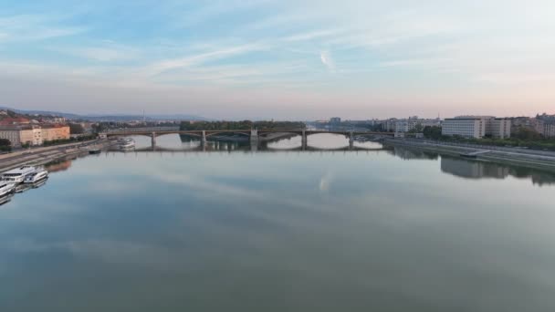 在日出时在匈牙利布达佩斯拍摄空中风景 玛格丽特桥或玛吉特隐藏在多瑙河的堤岸上 城市的公共交通 — 图库视频影像