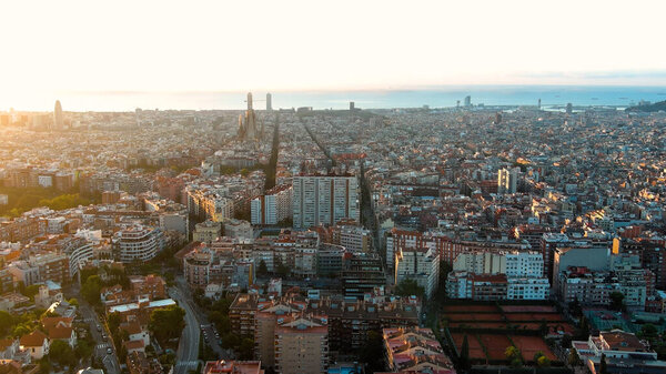 Aerial view of Barcelona skyline and Sagrada Familia Cathedral. Eixample residential famous urban grid. Cityscape with typical urban octagon blocks