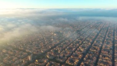 Bulutların ve sislerin üzerinde Barcelona Hava Aracı. Barselona şehir manzarasının tipik binaları. Eixample yerleşim bölgesi.