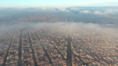 Bulutların ve sislerin üzerinde Barcelona Hava Aracı. Barselona şehir manzarasının tipik binaları. Eixample yerleşim bölgesi.