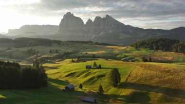 Seiser Alm Platosu 'ndaki Dolomitler' deki kır evleri, yaz sabahı ışığı. Sassolungo ve Sassopiatto tepeleri, Trentino Alto Adige, Güney Tyrol, İtalya, Avrupa