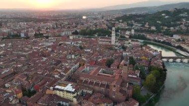 Günbatımında Verona şehrinin gökyüzü görüntüsünü kuran Duomo di Verona, Cattedrale di Santa Maria Matricolare, tarihi şehir merkezi, kırmızı kiremitli çatılar, Veneto Bölgesi, İtalya