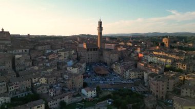 Torre del Mangia Kulesi 'nin havası ve Siena, İtalya' nın çatıları. Arkadaki Duomo di Siena, alçaktan uçuyor.