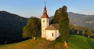 Slovenya, Skofja Loka yakınlarındaki bir tepenin üzerindeki St. Thomas Kilisesi 'nin hava manzarası.