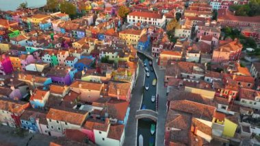 Venedik 'in Venedik bölgesindeki balıkçı tekneleri ve köprülerin yer aldığı Fondamenta seti boyunca gün doğumunda İtalya' nın Venedik bölgesinde bulunan Burano renkli evlerin hava manzarası.