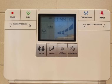 close up of modern automatic electronic toilet flush, digital device with buttons in restroom  clipart