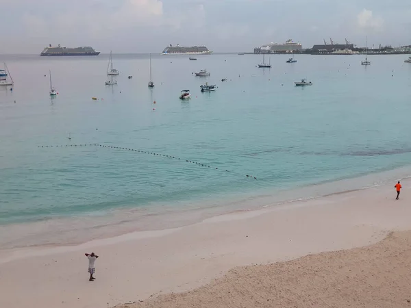 stock image beautiful tropical beach with blue water in the ocean, Barbados, unrecognized people walking on sand from distance. View on port, ships, vessels, cruises and fishing boats in harbor 