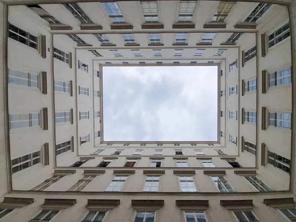 unusual angle, view from down on modern building in city, visual frame, many windows, high skyscraper