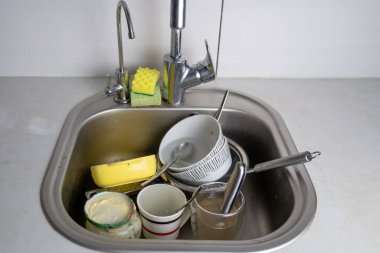 Mutfak lavabosunda kirli bulaşıklar, bulaşık yığını, sofra takımı, tembel ev kadını konsepti, mükemmeliyetçi cehennem 