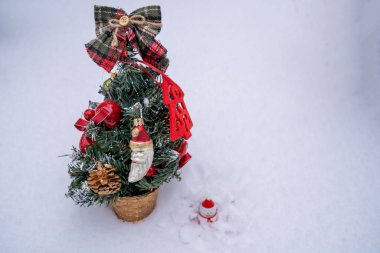 Noel ağacının altında, süsleri, süsleri ve kar beyazı arka planda oyuncakları olan köknar dalları olan bir kardan adam. Bayram kutlaması, yeni yıl kış zamanı. 