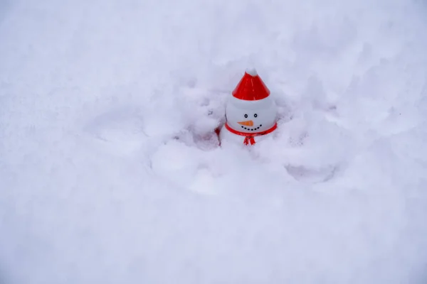 Bałwan Czerwonym Kapeluszu Siedzi Śniegu Koncepcja Świąt Bożego Narodzenia Nowego — Zdjęcie stockowe