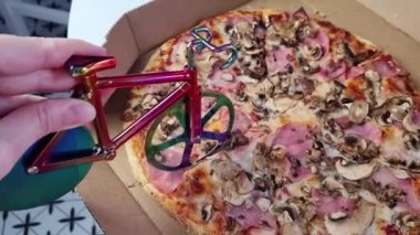 Masadaki karton kutuda lezzetli pizza dilimleri, kartondaki peynir üzerinde bisiklet pizzası bıçağı, fast food servisi. 
