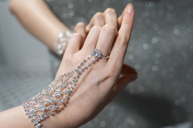 elegant woman hand with silver jewelry bracelet and ring. Reflection of hand in the mirror. Creative effect. Touching own reflection. Concept of loving and accepting yourself. 