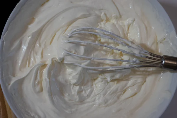 泡立て器でクリームのボウルを閉じます マスカルポーネソフトクリームチーズの食感 調理プロセス — ストック写真