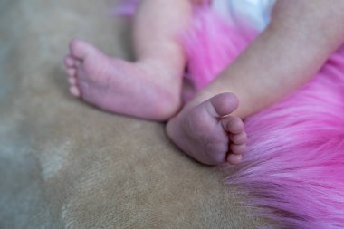 Yeni doğmuş şirin bir bebeğin ayaklarına, battaniyeye sarılmış küçük yumuşak bacaklarına