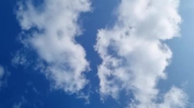 Aşırı hızlandırılmış hızlandırılmış video. Açık mavi gökyüzünde süzülen beyaz tüylü bulutlar. Huzur, sükunet, meditasyon. Güçlü rüzgar 