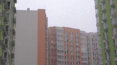 Kış manzarası, şehirde şiddetli kar yağışı, yeni bir apartmanın pencere manzarası, şehirde ilk kar. 