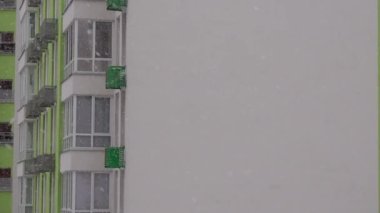 Kış manzarası, şehirde şiddetli kar yağışı, yeni bir apartmanın pencere manzarası, şehirde ilk kar. 
