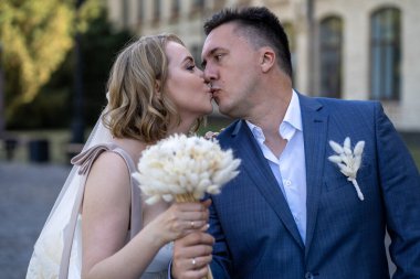 Düğün günü. Gelin ve damat sokakta öpüşüyor. Yeni evlendim ve yeni bir aile kurdum. Düğün portresi 