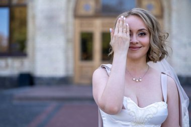 Beyaz gelinlik içinde elinde bir buket çiçekle güzel bir gelinin portresi. Düğün günü. Açık havada gelin fotosferi