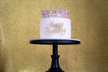 Pasta tutacağında taçlandırılmış simli pasta. Altın kaplamalı doğum günü pastanız kutlu olsun. Doğum günü kraliçesi tarzı kutlama 