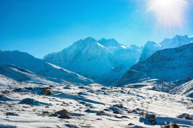 Güneşli bir günde karlı dağ manzarası.
