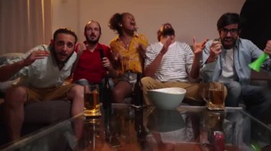 Televizyonda spor maçı izleyen beş duygusal yetişkin arkadaştan oluşan bir grup kanepede oturan takımının zaferini kutluyor. Spor Konsepti. Yüksek kalite 4k görüntü
