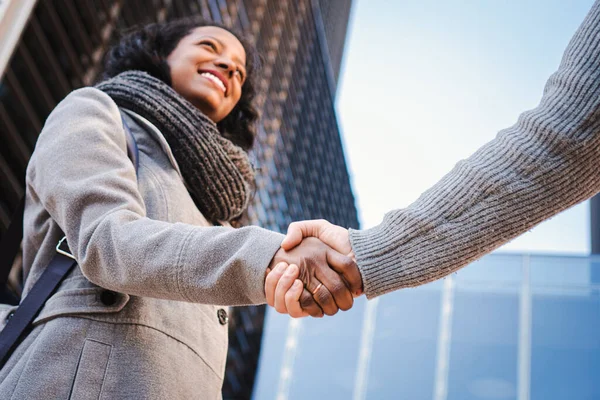 Welcoming business woman giving a handshake and smiling finishing successful meeting. Greeting concept. High quality photo
