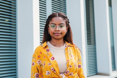 Açık havada izole edilmiş bir şekilde kameraya bakan İspanyol asıllı ciddi bir kızın portresi. Gözlüklü genç Latin kadının vesikalığı. Yüksek kalite fotoğraf