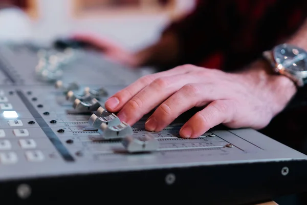 stock image Close up portrait of hands working on sound mixer console for recording, broadcasting or music production. Engineer using studio Audio Mixer Knobs And Faders. Audio Concept. High quality photo