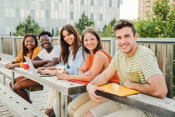 幸せな10代の学生がカメラを見て 大学のキャンパスの外で一緒に休憩を取ってリラックスした笑顔の多人種グループ 太陽の光を楽しむ若者と楽しい大学生の出会い — ストック写真