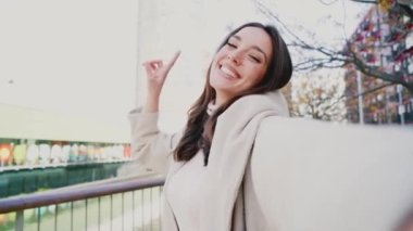Parkta ayakta duran gülümseyen genç bir kadının selfie portresi. Akıllı bir telefonla fotoğraf çekerek ve sosyal medyada paylaşarak eğlenen mutlu bir kız. Yüksek kalite fotoğraf