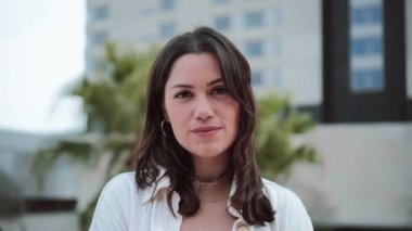 Bir kadın yüzünün yakın portresi. Bir kızın kafasının ön görüntüsü. Kameraya gülümseyen yalnız bir genç kadın. Açık havada duran beyaz bir kız. Yüksek kalite fotoğraf