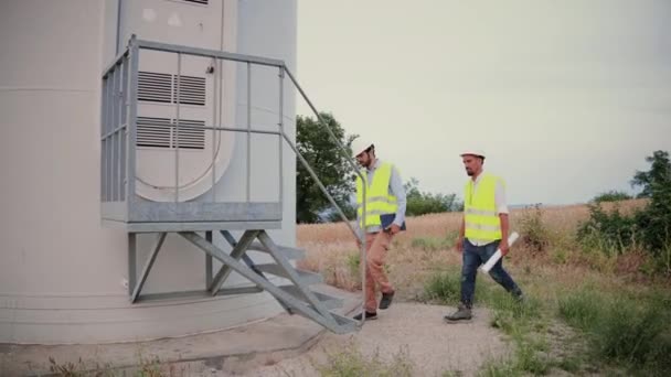 Dos Ingenieros Técnicos Molinos Viento Hablan Caminan Planifican Una Construcción — Vídeo de stock