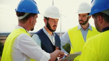 Yenilenebilir enerji mimarı ve mühendislerinin bir tablet cihazının planını okuyan ve inşaatı birlikte planlayan takım çalışmalarına yakından bakın. Güç endüstrisi konsepti. Ağır çekim. Yüksek kalite