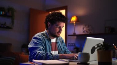 Evde dizüstü bilgisayarla çalışan, not defterinde kurşun kalemle yazı yazan, Kafkas kökenli genç, serbest çalışan bir adam. Girişimci profesyonel erkek finansmanı kontrol ediyor. Geceleri masada oturuyor.