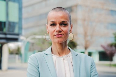 Profesyonel işiyle gurur duyan takım elbiseli başarılı bir iş kadınının portresi. Bir yönetici kadın çalışma yerinde duruyor. Güvenilir başlangıç CEO 'su veya kameraya bakan çalışan